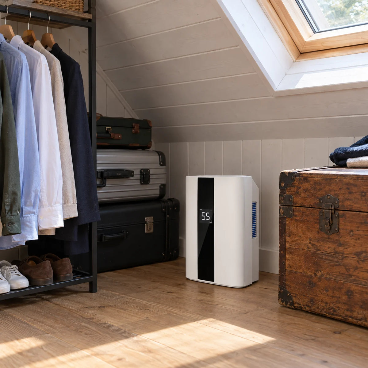 Déshumidificateur Aura Air Home Confort, blanc à bande noire, au sol d'un dressing sous les combles